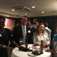 Three women and and one man sitting at a table socializing